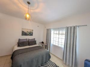 Manna guest house في هراري: غرفة نوم بها سرير ونافذة