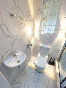 Manna guest house في هراري: حمام أبيض مع مرحاض ومغسلة