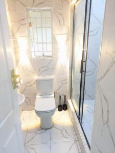 Manna guest house في هراري: حمام ابيض مع مرحاض ودش +10 صور