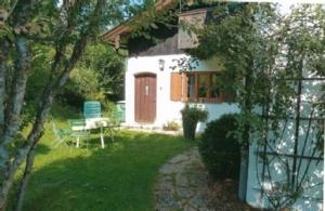 een klein huis met een rode deur en een tuin bij BergZeit Apartment in Berchtesgaden