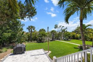 un giardino con palme e una recinzione bianca di Beach Daze Sanibel a Sanibel
