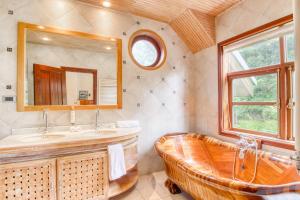 un bagno con vasca, lavandino e specchio di Casa Ko, tu refugio a la entrada de la patagonia a Puerto Varas