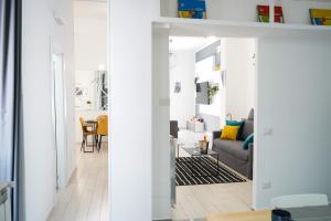 a living room with white walls and a gray couch at Scugnizzo Apartment CHIAIA in Naples