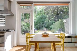 a kitchen with a table and chairs and a large window at Veluwe Nature Home - 2 persons in Otterlo