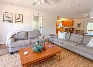 a living room with two couches and a coffee table at NEW- Canal Front 3 bedroom Boat dock & Launch in St. George Island