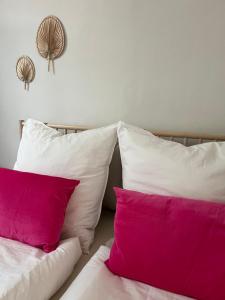 a bed with two pink pillows and two white pillows at Zentrale Ferienwohnung in Minden in Minden
