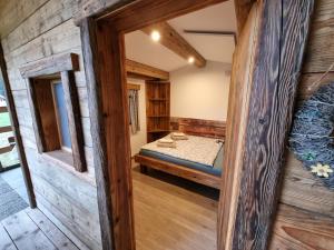 a room with a bed and a wooden wall at western cottage in Rečica ob Savinji