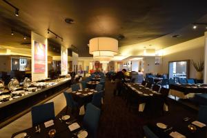 a dining room with many tables and blue chairs at Abell Hotel in Kuching