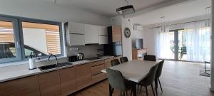 a kitchen with a table and chairs in a room at Garden Baltic II in Trzęsacz