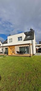 a house with a bench in front of a yard at Garden Baltic II in Trzęsacz