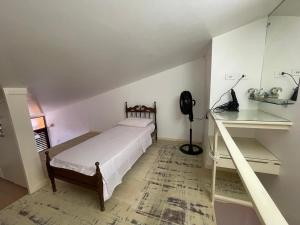 a small bedroom with a bed and a desk at CONDOMÍNIO IMPERIAL, PRAIA DO FRANCÊS in Praia do Frances