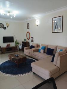 a living room with two couches and a coffee table at The Abode2 Entebbe in Entebbe