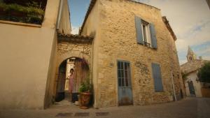 a woman standing in the doorway of a stone building at Les chambres d'Elise in Collias