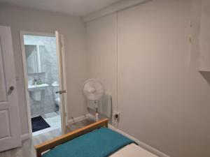 a white bathroom with a mirror and a sink at Aafiyat House in Aldershot