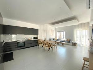 a large white kitchen with a table and chairs at GBR 2 - Golden Beach Residences in Chrissi Akti