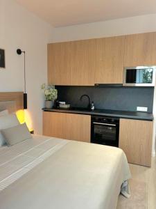 a bedroom with a white bed and a kitchen at Studio Tabacariei 5A in Tăbăcărie