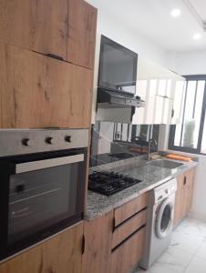 a kitchen with a stove top oven next to a sink at للا ربيعة بيتي in Kenitra