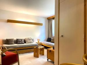 a living room with a couch and a table at Résidence Hameaux De Val - Appartement accueillant et son parking couvert MAE-5781 in Val dʼIsère
