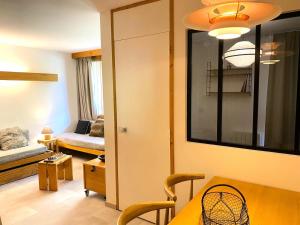 a living room with a table and a room with a couch at Résidence Hameaux De Val - Appartement accueillant et son parking couvert MAE-5781 in Val dʼIsère