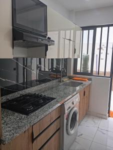 a kitchen with a sink and a stove top oven at للا ربيعة بيتي in Kenitra