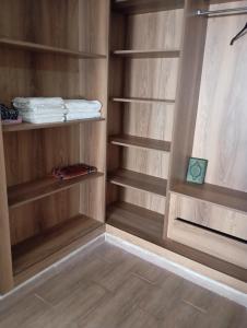 a walk in closet with wooden shelves and towels at للا ربيعة بيتي in Kenitra