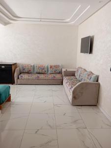 a living room with two couches and a tv at للا ربيعة بيتي in Kenitra +16 photos