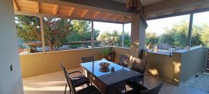 a patio with a table and chairs on a balcony at Country Nest in Messini
