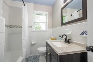 a bathroom with a sink and a toilet and a mirror at Comfort & Space in Prime Cartersville Spot in Cartersville +28 photos