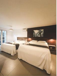 a hotel room with three beds with white sheets at Alua Camburi in Camburi +37 photos