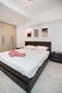 a large bedroom with a large bed with white sheets at Ilissos Harmony Apartment in Piraeus