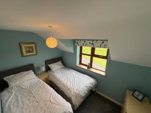 a bedroom with two beds and a window at Modern Country Loft, Ballymena in Teeshan