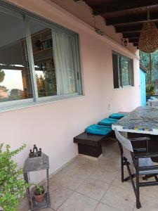 a patio with a table and a bench with blue pillows at Κτήμα Εμιαλη in Kalamákion +27 photos