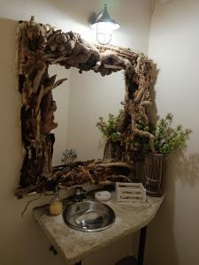 a bathroom with a sink and a large mirror at Κτήμα Εμιαλη in Kalamákion