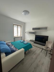a bedroom with a bed and a couch and a tv at Appartamento EM in Pavia