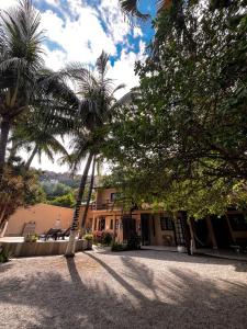 a building with palm trees in front of it at Solar da Praia Pousada in Arraial do Cabo