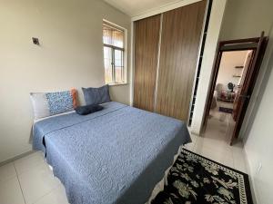 una camera da letto con un letto blu e uno specchio di Quarto individual ou casal a Belém