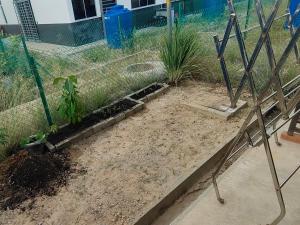 a garden with a fence and some plants at Tuaran 88 Homestay in Tuaran