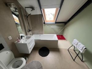 ein Badezimmer mit Badewanne, Waschbecken und Toilette in der Unterkunft MECHELinn in Mechelinki + 31 Fotos