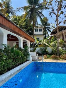 a swimming pool in front of a villa at Sun-kissed Holidays, Goa - Copper in Serula