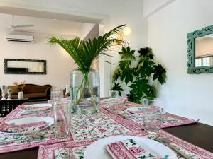 a table with plates and a vase with a plant at Sun-kissed Holidays, Goa - Copper in Serula