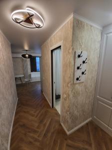 a hallway with a ceiling fan and a hallway with wood floors at Апартаменты 2 in Karagandy