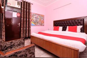 a bedroom with a large bed and a chair at Hotel O Simran in Chandīgarh