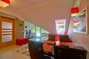 - une salle à manger avec une table et un canapé rouge dans l'établissement StaraPolana.EU & SPA, à Zakopane