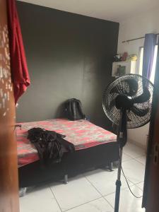 Un dormitorio con una cama y un ventilador. en Residencial Juscelino Kubitscheck, en Ananindeua