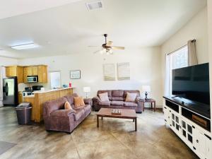 a living room with two couches and a flat screen tv at Chateau 14 in Hammond