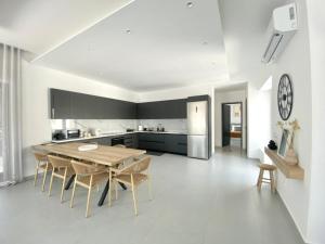 a kitchen and dining room with a table and chairs at GBR 1 - Golden Beach Residences in Chrissi Akti
