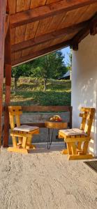 two wooden benches and a picnic table under a pavilion at Village House in Veruša