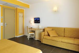 - un salon avec un canapé et un bureau dans l'établissement Hotel Stella Marina, à San Vincenzo