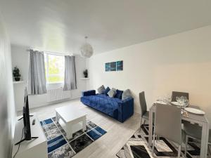 South NorwoodにあるCosy 2 bed flat Near East Croydonの青いソファとテーブルのあるリビングルーム
