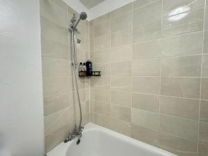 South NorwoodにあるCosy 2 bed flat Near East Croydonのシャワーとバスタブ付きのバスルーム